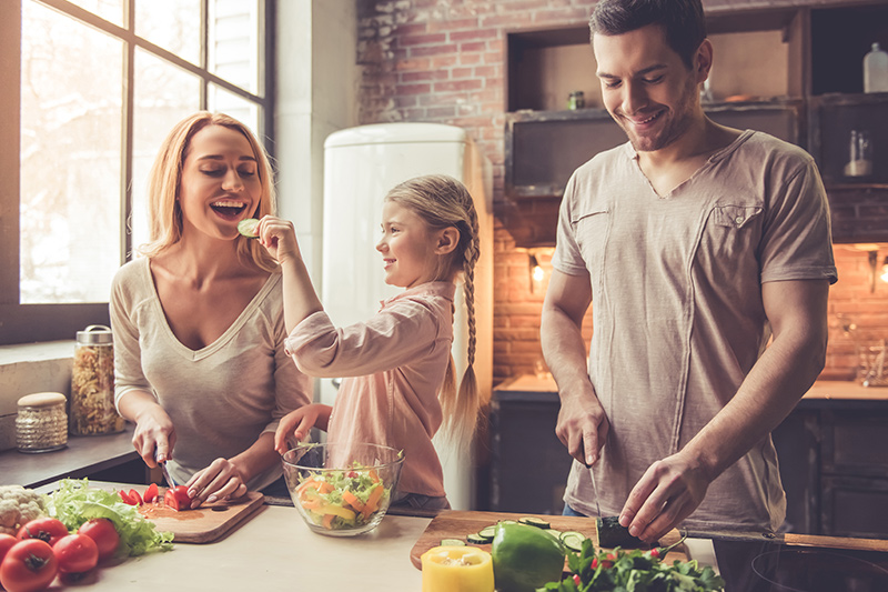 A family prepareing a meal in their kitchen