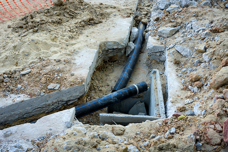 image of exposed pipes under concrete
