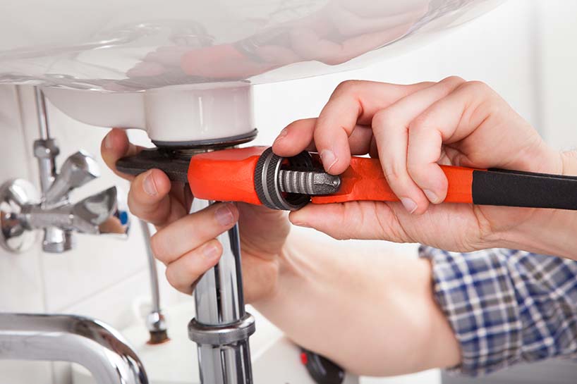 Photo of a plumber installing a new pipe