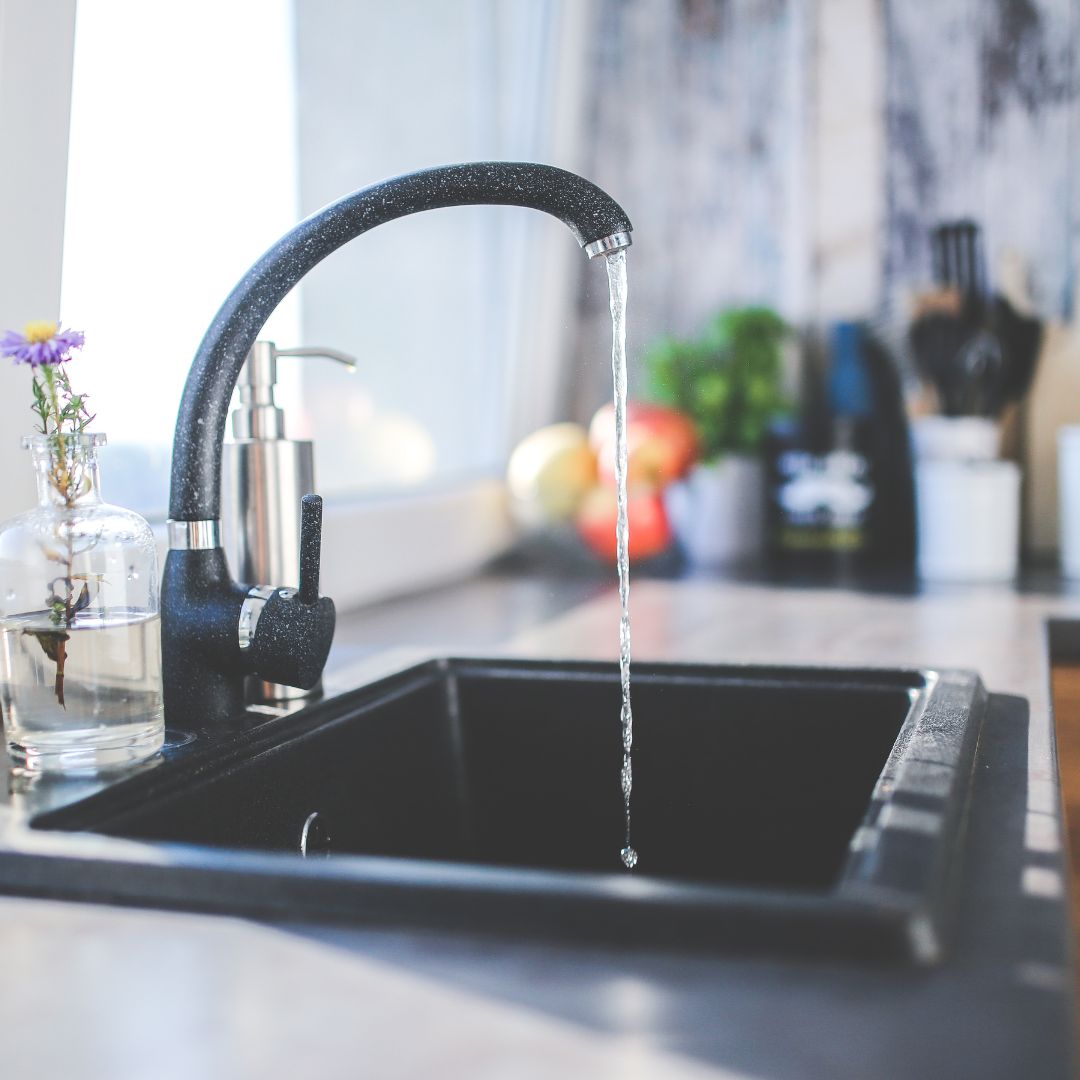 Water running from a kitchen sink faucet.