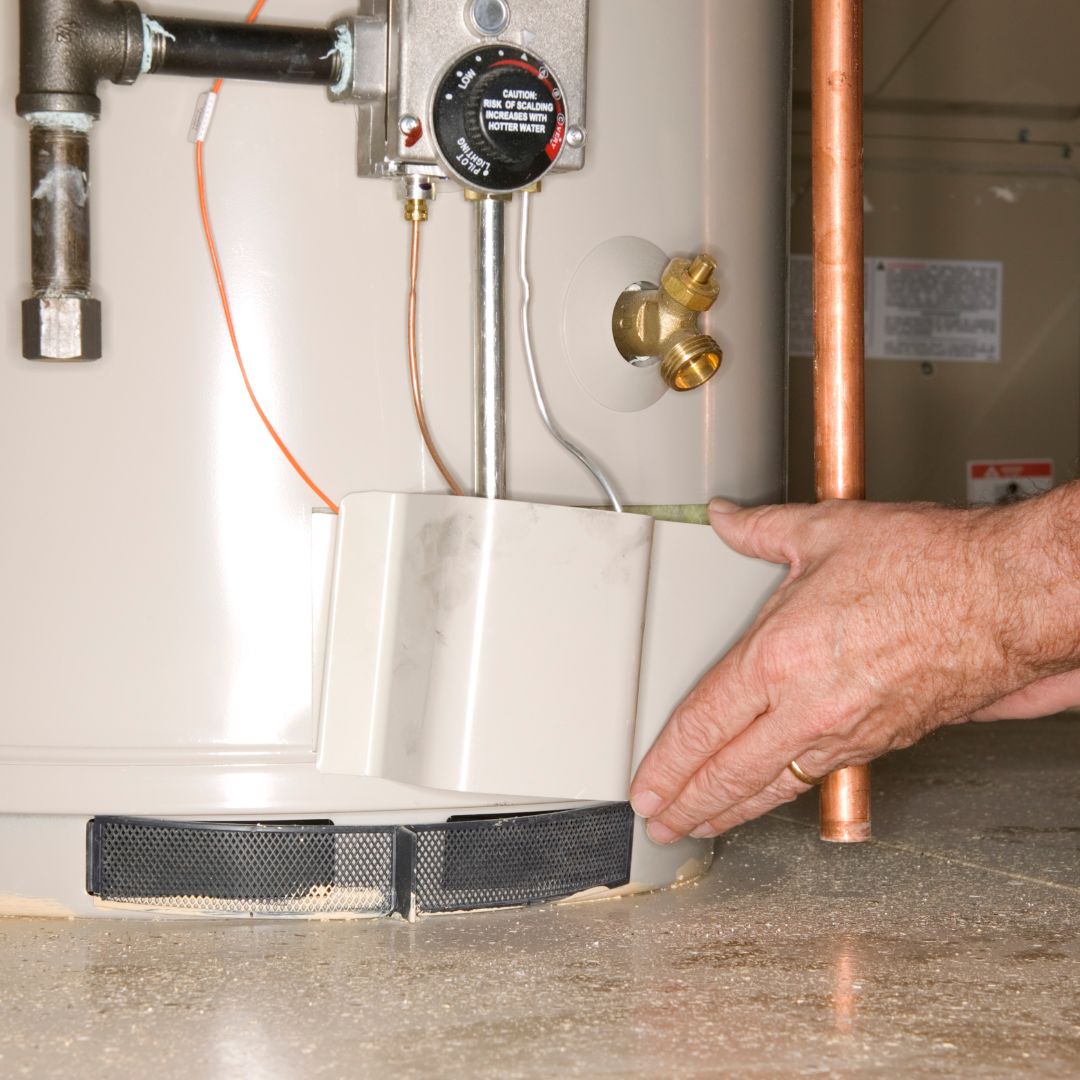 man checking bottom of a water heater
